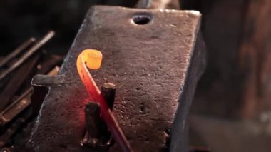 Demirci bir spiral içinde bükülür. Dikdörtgen ısıtılmış bir metal parçası çekiçle ona çarpar.