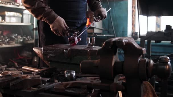 De mens smid buigt de bladeren van een metalen roos met tang — Stockvideo