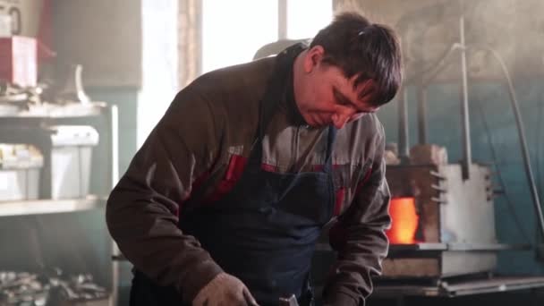 Muž kovář tvořící list z horkého kusu kovu — Stock video
