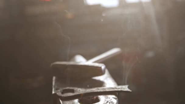 Курение черного металла подробно на наковальню и солнечный свет, входящий в комнату — стоковое видео