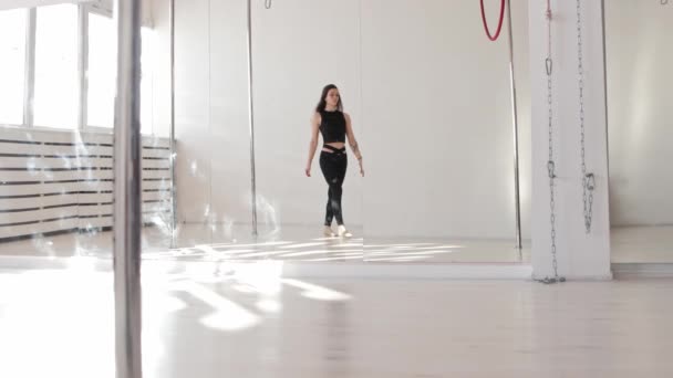 Giovane donna cammina verso un anello appeso sotto il soffitto e guarda nella fotocamera — Video Stock