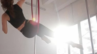 Genç bir kadın jimnastik ringinde dönüyor.