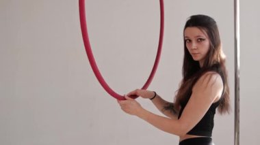 Genç bir kadın jimnastik ringinde hava atıyor.