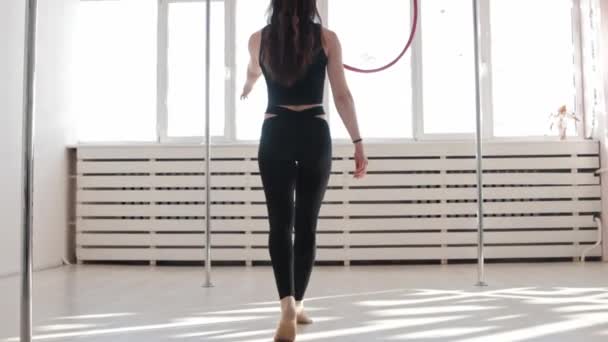 一位年轻的体操女子从天花板下走到拳击台前，爬上拳击台，绕着自己旋转 — 图库视频影像