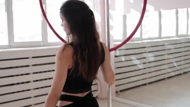 एक युवा महिला स्टूडियो में जिम्नास्टिक अंगूठी के चारों ओर चमकती है — स्टॉक वीडियो