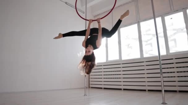 Una giovane donna ginnica che esegue trucchi sul ring appeso sotto il soffitto — Video Stock