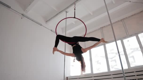 Una giovane donna ginnica che gira sull'anello appeso sotto il soffitto — Video Stock