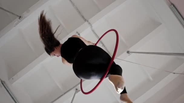 Egy fiatal tornász nő ül akrobatikus gyűrűn és pörög a levegőben. — Stock videók