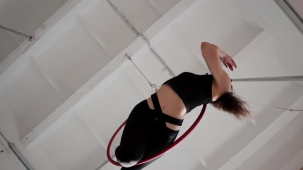 Una joven gimnasta colgando en el anillo acrobático y girando en el aire — Vídeo de stock