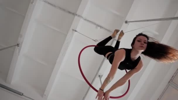 Egy fiatal nő akrobatikus gyűrűn lóg és pörög a levegőben. — Stock videók