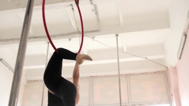 A young woman gymnast spins in an acrobatic ring — Video Stock