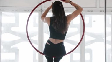 Jimnastik eğitimi - genç bir kadın akrobatik bir yüzüğe oturur - başıyla sarkar