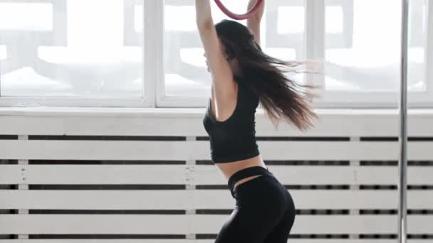 Фитнес - молодая женщина гимнастка с татуировкой, висящей на акробатическом кольце и вращающейся на нем — стоковое видео