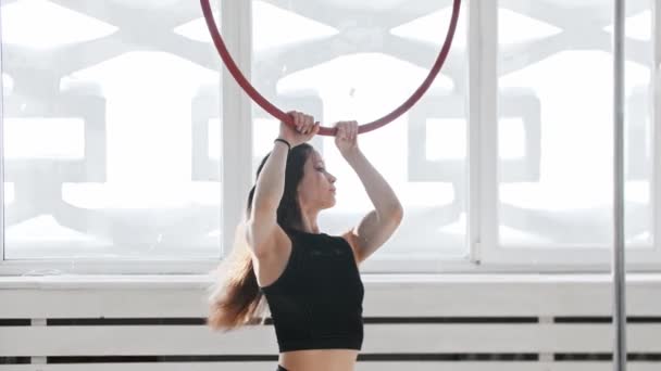체조 훈련 - 젊은 여자가 곡예를 하는 반지에 뛰어올라 그것을 빙빙 도는 모습 — 비디오