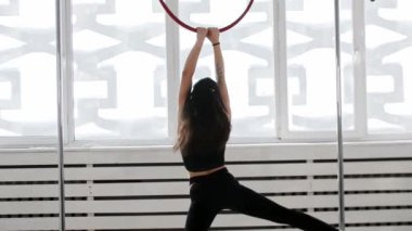 Jimnastik eğitimi. Dövmeli genç bir kadın. Akrobatik bir yüzük takıyor ve etrafında dönüyor.