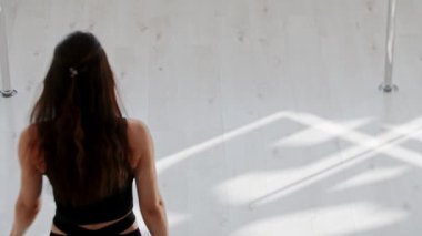 Jimnastik eğitimi - genç bir kadın tavanın altında asılı bir akrobatik ringe yürür