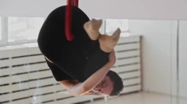 Beyaz stüdyodaki akrobatik halkada dönen genç jimnastik kadını.