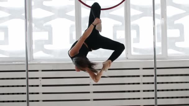 Gymnastiektraining - jonge vrouw houdt de acrobatische ring vast met haar been en draait rond — Stockvideo