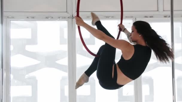 Entraînement gymnastique - une jeune femme tatouée monte sur l'anneau acrobatique avec les deux pieds — Video