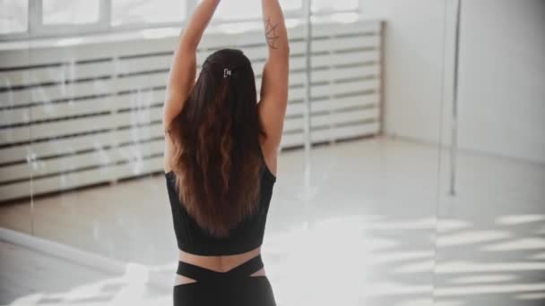 Antrenament gimnastic - o femeie tânără ține de un inel acrobatic și începe să se rotească pe el — Videoclip de stoc