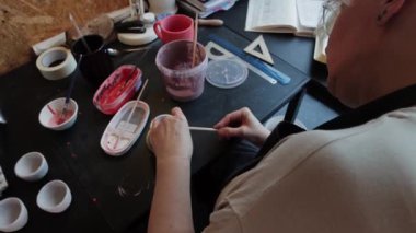 Yaşlı bir kadın seramik bir şeyde ara veriyor.