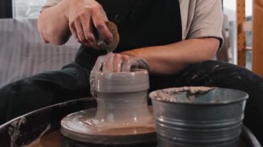 Yaşlı bir kadın direksiyondan kilden demlik yapıyor.