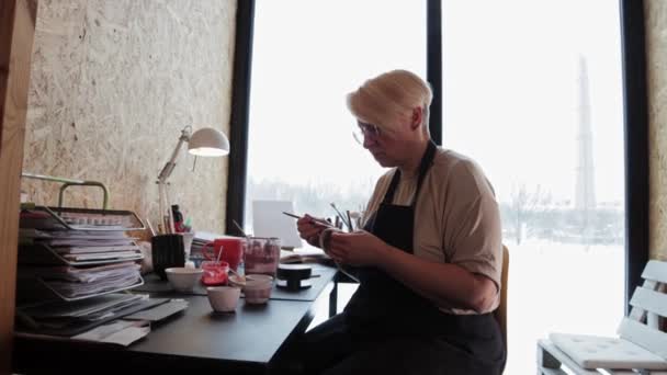 一个老年妇女用刷子画陶瓷杯子 — 图库视频影像