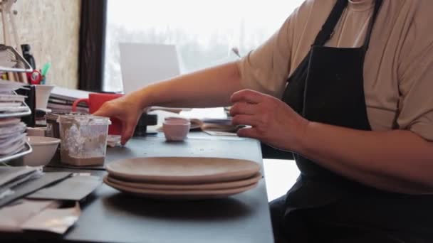 한연로 한 여인이 페인트 그릇을 식탁에 쌓아 놓는다 — 비디오