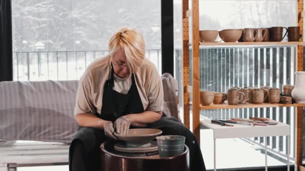陶器- -在轮子上的宽盘子里塑造湿粘土的老年妇女 — 图库视频影像