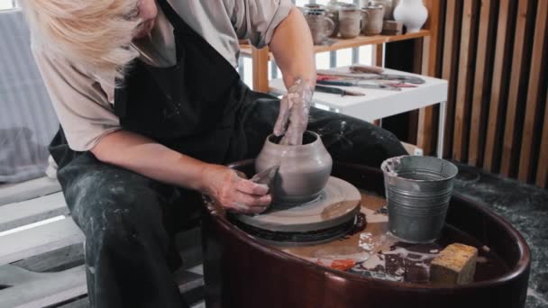 Keramik - en äldre kvinna som formar lerkrukan med hjälp av händer och kam — Stockvideo