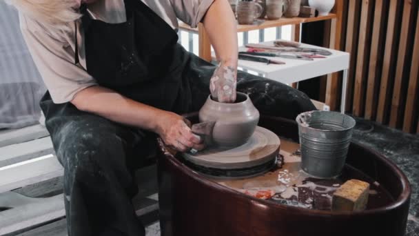 Keramik - en gammal kvinna som formar lerkrukan med hjälp av sina händer och träkam — Stockvideo