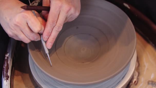 Žena používající síťku k vytváření rýh na hliněném talíři — Stock video