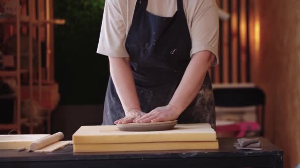 An eldery woman making a clay plate using a shape on big sponge stand — 비디오