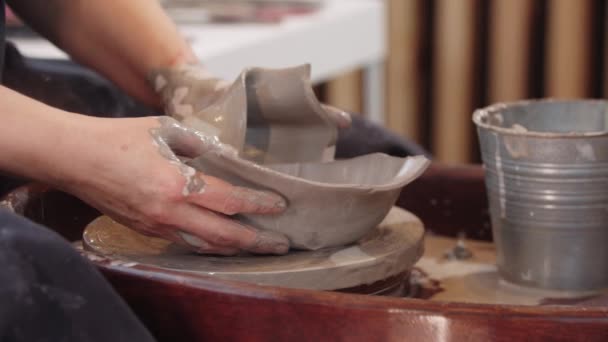 En äldre kvinna krukmakare omformar mjuk lera — Stockvideo