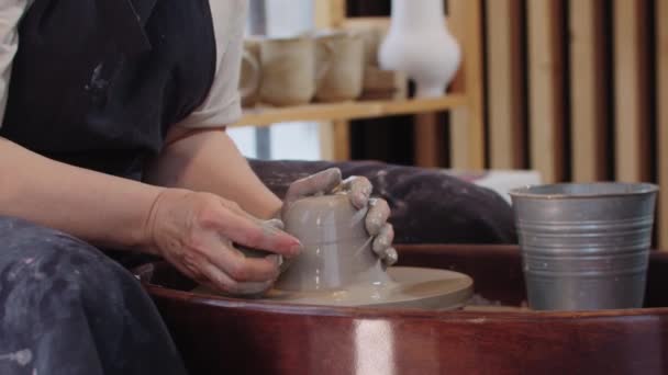 Pottery - tvarování mokrý kus hlíny na keramické kolo — Stock video