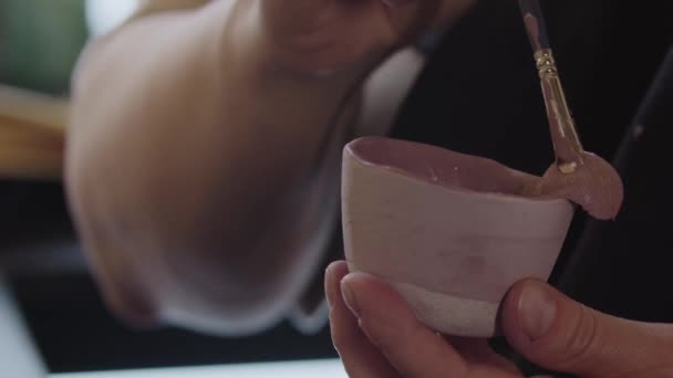 Painting clay item in dusty rose color with a brush — Vídeo de Stock