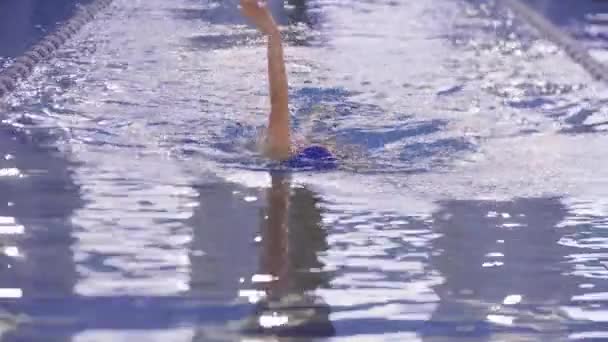 一位年轻女子在游泳池边的小径上游泳 — 图库视频影像