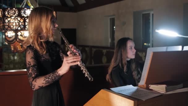 Flutist and organist rehearse a performance in church — Stok video