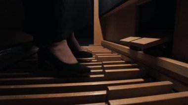 Genç bir kadın ayaklarıyla elektronik organ çalıyor.