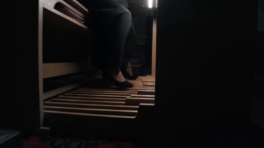 Genç bir kadın ayaklarıyla pedallara dokunarak elektronik organ çalıyor.