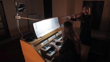 Elektronik org ve flüt çalan kadın flütçü.