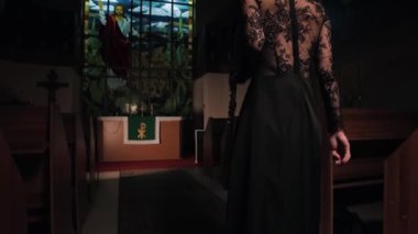 Young woman walks to a stand in the church and starts playing on the flute