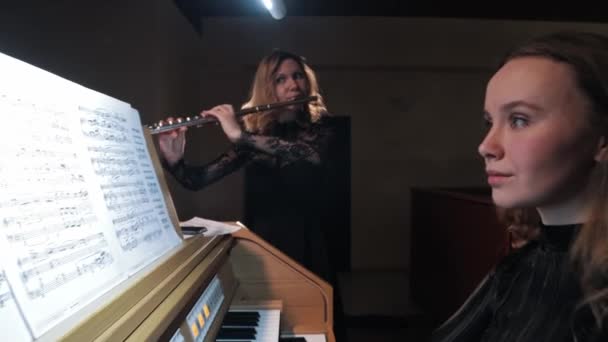 Ženský flétnista a varhaník hrající noty v kostele — Stock video