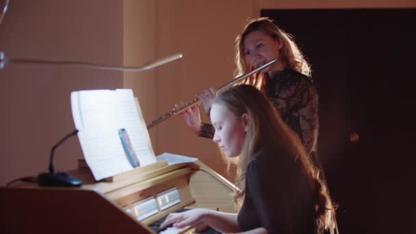 Ensaio musical - flautista feminina e organista tocando música na igreja — Vídeo de Stock