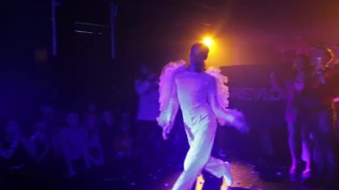 RUSSIA, KAZAN 20-02-2022: Beyaz provakatif kostümlü bir adam gece kulübünde dans ediyor