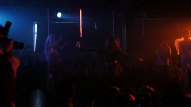 RUSSIA, KAZAN 20-02-2022: Siyah elbiseli esnek bir kız bir gece kulübünde dans ediyor.