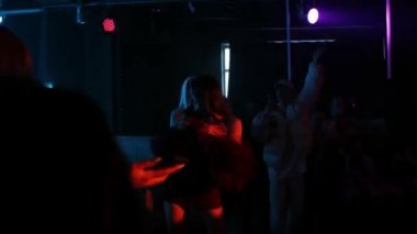 RUSSIA, KAZAN 20-02-2022: Bir gece kulübünde dans eden gülümseyen seksi kız