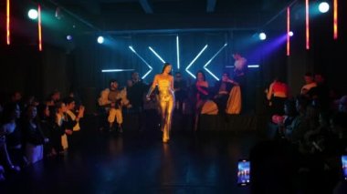 RUSSIA, KAZAN 20-02-2022: çarpıcı kostümlü uzun saçlı seksi kadın bir gece kulübünde sahneye çıkıyor.