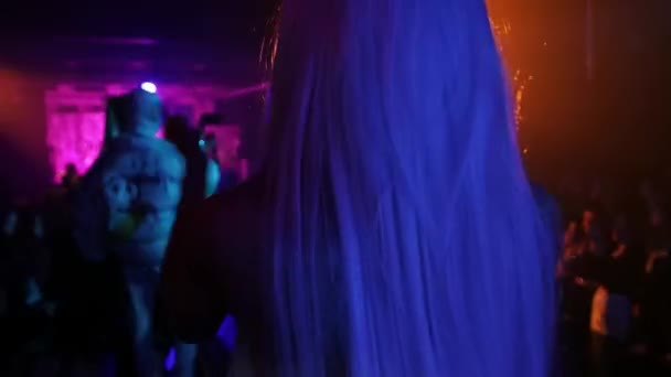 RUSSIA, KAZAN 20-02-2022: a young man in a leather jacket and a fabric mask walks on the stage in a nightclub — Vídeo de stock