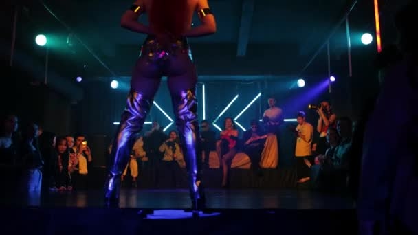 RUSSIA, KAZAN 20-02-2022: a young woman in a stunning costume and with long nails walks on the stage of the club and begins a dance number — Vídeo de Stock